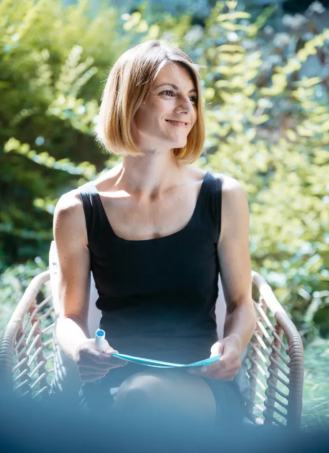 Christine Hoffmann-Schütz sitzt im Garten ihres Garden Lofts & erklärt den Teilnehmenden psychologisches Coaching.